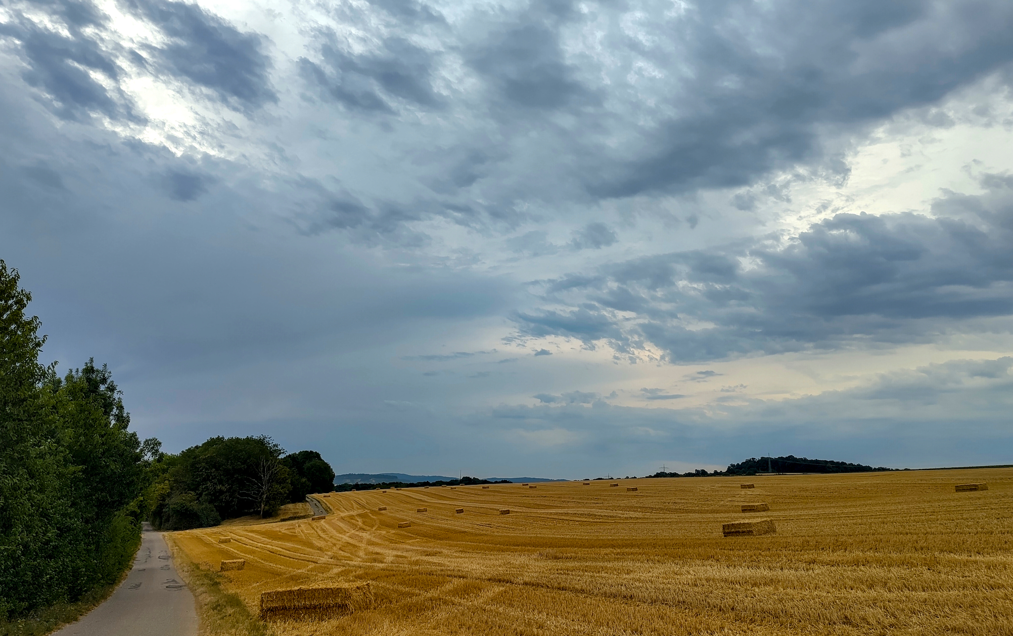 Morgens am Dietersberg bei Ilsfeld. Eine ländliche Szenerie mit abgeernteten Getreidefeldern und Strohballen. Der Himmel ist von dichten Wolken bedeckt, was auf einen möglichen Wetterumschwung hindeuten könnte, der aber erst Tage später kam.