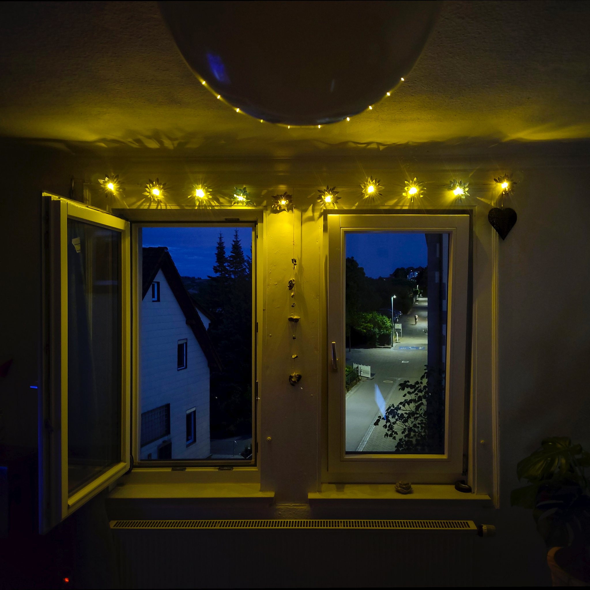 Unser Wohnzimmerfenster mit einer warmweißen Lichterkette, die es gemütlich macht.