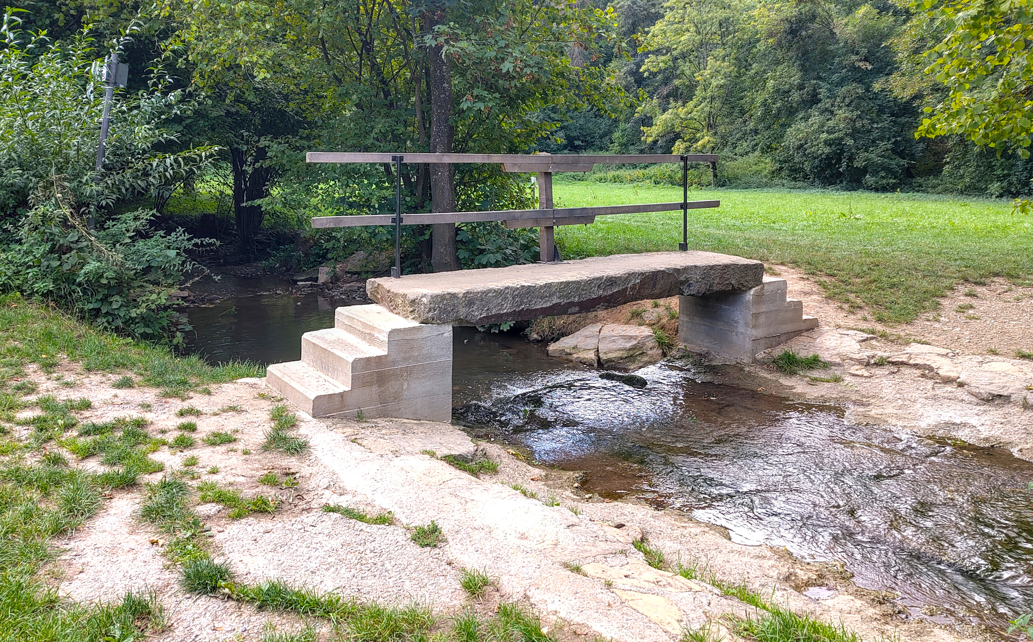 Das Bild zeigt die Fußgängerbrücke und Furt am Baumbach im Baumbachtal bei Walheilm. Die neue Brücke. Die alte wurde wegen Hochwasser beschädigt. Sie war allerdings sehr viel netter anzusehen.