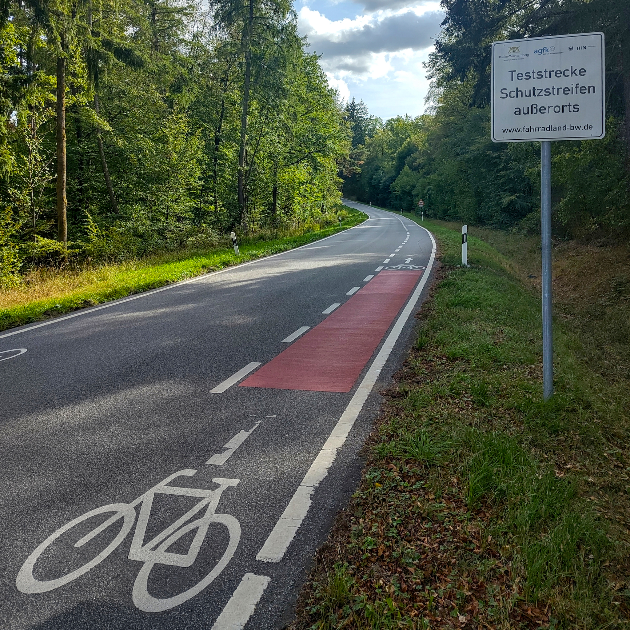 Das Bild zeigt eine Teststrecke für außerorts markierte Fahrradschutzstreifen bei Heilbronn im Rahmen eines Modellprojekts der AGFK-BW. Ein mächtig schützender Streifen ist das. Total sicher.